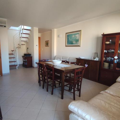 Una sala de estar con una mesa y sillas y un sofá. en Casa vacanze Colle della Minerva, en Otranto