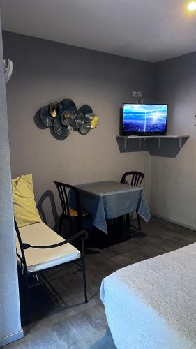 a room with a table and a tv on the wall at La Chaumiere d Agde in Agde