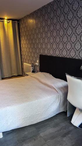 a bedroom with a large bed and a chair at La Chaumiere d Agde in Agde