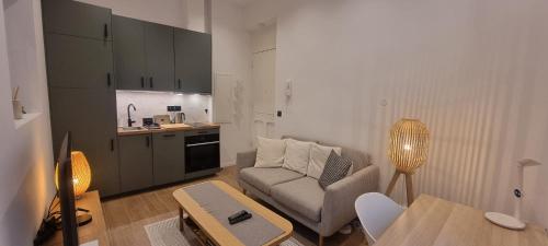 un salon avec un canapé et une table dans l'établissement Très joli 2 pièces à côté de l'AC Hotel Marriott Nice, à Nice