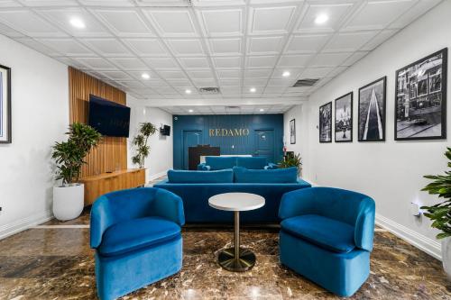 a waiting room with blue chairs and a table at Redamo Suites in Jefferson