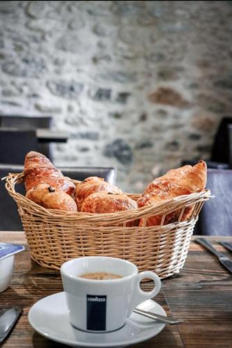 - un panier de pain et une tasse de café sur une table dans l'établissement Logis Hotel Les Glycines, à Arles-sur-Tech