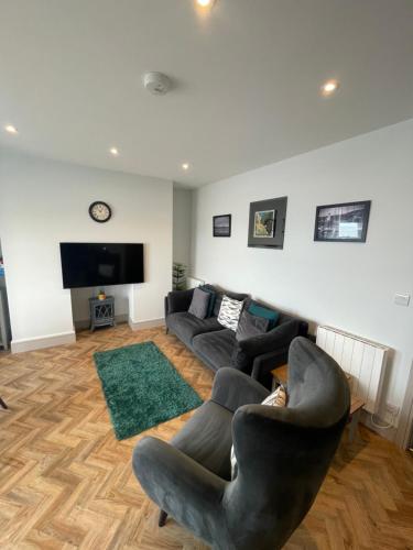 a living room with a couch and a tv at Superb 2 Bedroom Sea View Flat in Scarborough