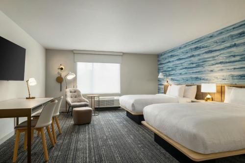 a hotel room with two beds and a desk at TownePlace Suites by Marriott Duluth in Duluth