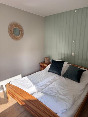 a bedroom with a bed with white sheets and blue pillows at Domek nad jeziorem Łagów - Mundi, Lake Park in Łagów