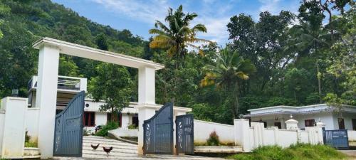 a building with a gate and a fence at Mamalakandam - The White house, Diya homestay in Mamalakandam