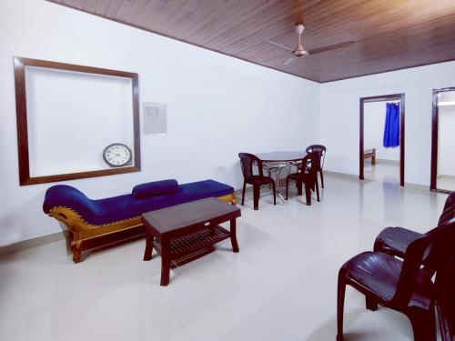 a living room with a blue couch and a table at Mamalakandam - The White house, Diya homestay in Mamalakandam