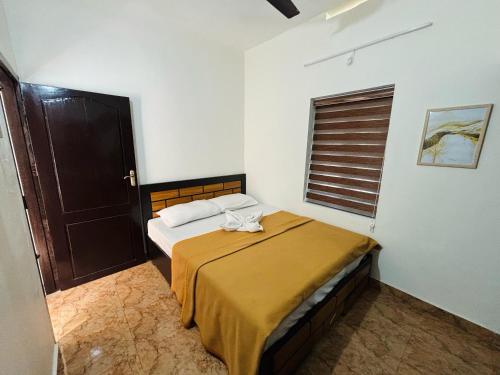 a bedroom with a bed in a room with a window at Stay Kattil Varkala in Varkala