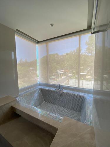 a bathroom with a bath tub with a window at Beachfront in Ban Lum Fuang