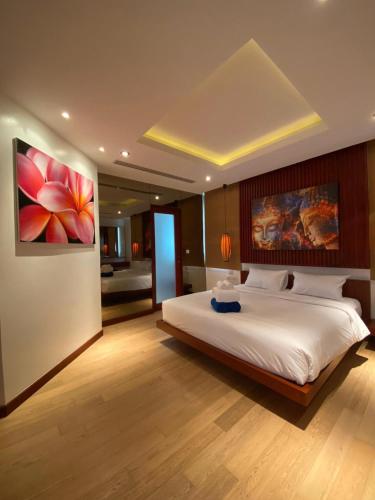a bedroom with a large bed and a painting on the wall at Beachfront in Ban Lum Fuang