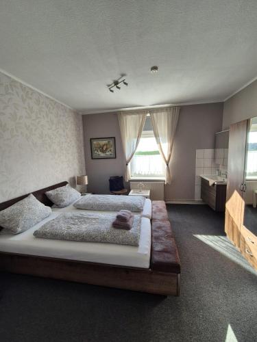 a large bedroom with two beds and a window at Ostsee Pension Pohnsdorfer Mühle in Sierksdorf