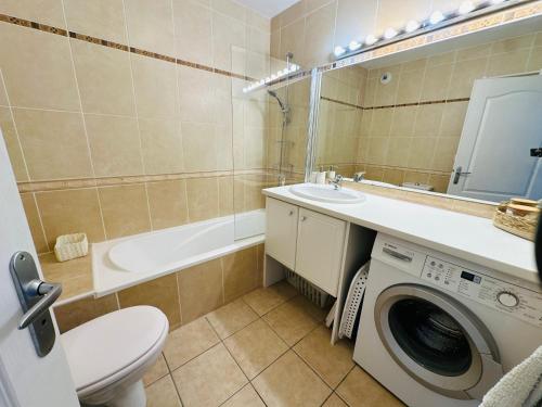 une salle de bain avec une machine à laver et un lave-linge dans l'établissement L'ECUME DES VAGUES- Spacieux 3 chambres Familial Tout Confort au Calme, Climatisé et Piscine, adapté au télétravail, à Saint-Cyprien