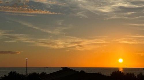 a sunset over the ocean with the sun in the sky at MDF Monolocale a Fregene 100 mt dal mare in Fregene