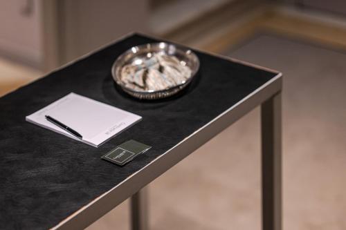 a black table with a plate and a pen on it at Contrada 18 in Oderzo