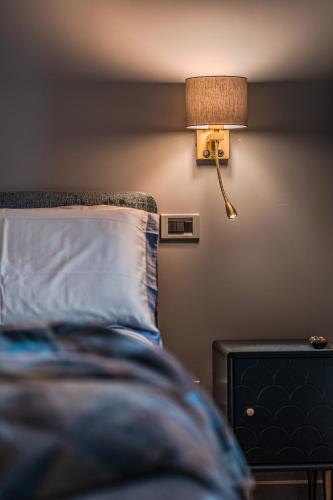a bedroom with a bed with a lamp on the wall at Contrada 18 in Oderzo