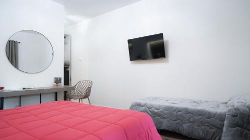 a bedroom with a bed and a desk and a mirror at Gira e Firria in Palermo