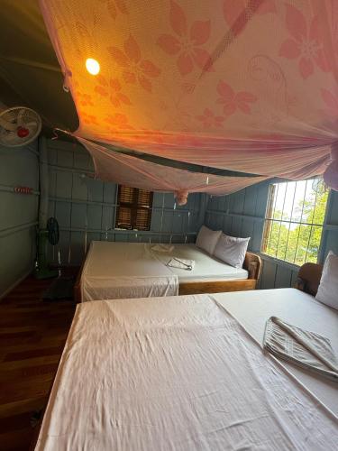 a bedroom with two beds and a ceiling with flowers at Sweet View Guesthouse in Koh Rong
