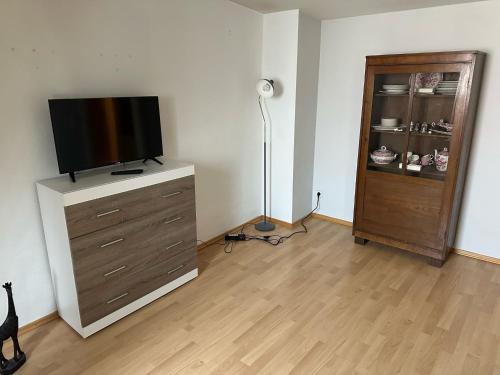 a living room with a flat screen tv on a dresser at Pension La rose in Brandenburg an der Havel