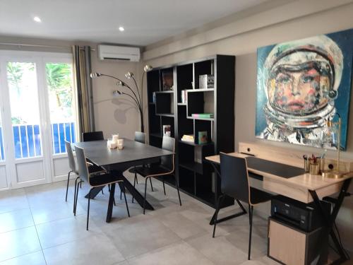 une salle à manger avec une table et des chaises et un tableau dans l'établissement Magnifique T3 à 100m des plages, à Carqueiranne