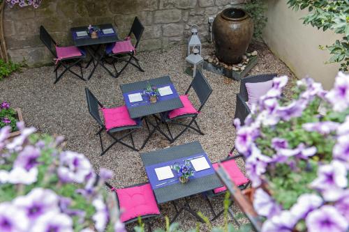 a group of tables and chairs with purple flowers at Torre Di Vico Residenza D'Epoca in Viterbo