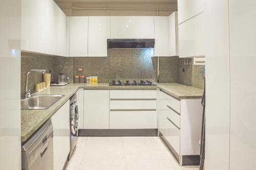 a kitchen with white cabinets and a sink at شقة فندقية الشيخ زايد - Zayed Suites F in Sheikh Zayed