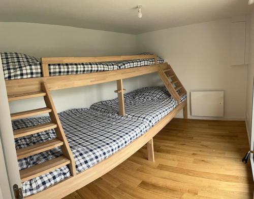 deux lits superposés dans une chambre avec parquet dans l'établissement Magnifique villa à deux pas de la plage, à La Celle-sous-Gouzon