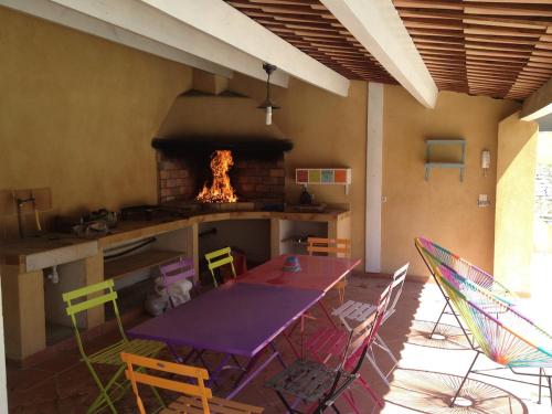 Il comprend une cuisine équipée d'une table, de chaises et d'un four. dans l'établissement Superbe villa provençale, à Ventabren