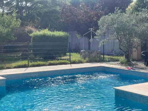 une piscine avec de l'eau bleue dans une cour dans l'établissement Superbe villa provençale, à Ventabren
