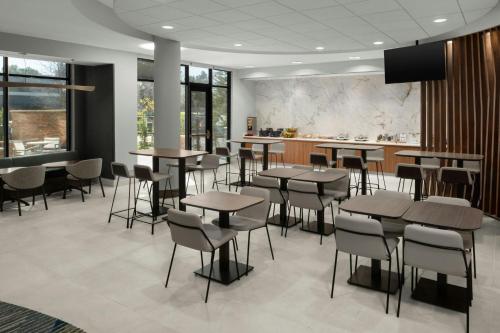 a restaurant with tables and chairs and a kitchen at SpringHill Suites Irvine John Wayne Airport / Orange County in Irvine