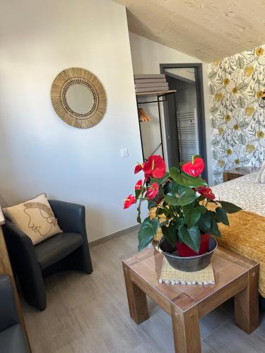 - un salon avec une table et une plante en pot dans l'établissement La Rose des Vents, à Loix
