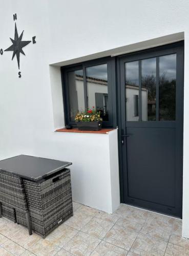 une porte d'entrée d'une maison avec une fenêtre dans l'établissement La Rose des Vents, à Loix