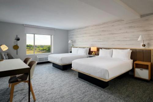 a hotel room with two beds and a desk at TownePlace Suites by Marriott Fort Myers Southeast in Fort Myers
