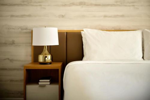 a bed with a lamp on a night stand next to it at TownePlace Suites by Marriott Fort Myers Southeast in Fort Myers