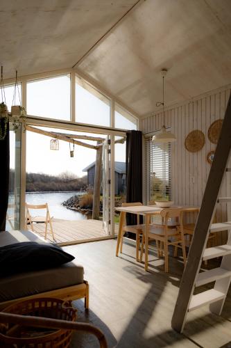 a living room with a table and a dining room at Brouwersdam Stay in Ouddorp