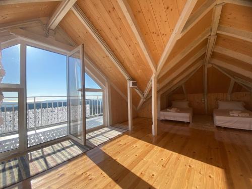 Habitación en el ático con cama y ventana grande en Meti guest house wooden room, en Krujë
