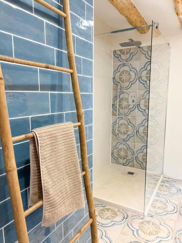 a bathroom with blue tiles and a ladder with a mirror at Can Jan Vives in Vidreres