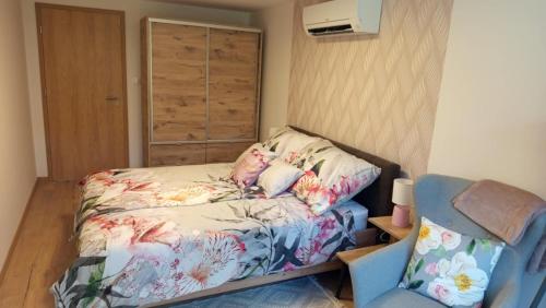 a small bedroom with a bed and a chair at Dalma Vendégház Velem in Velem