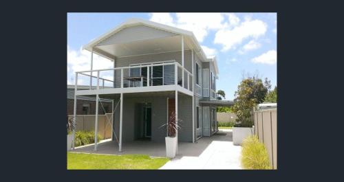 a large house with a balcony on top of it at Riverside Kingdom Goolwa in Goolwa