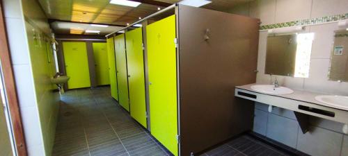 une salle de bain avec des murs et des lavabos verts et marron dans l'établissement Pod, à Camoël