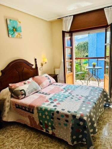 a bedroom with a bed and a balcony with a table at Hotel las Palmeras Suite in Celorio