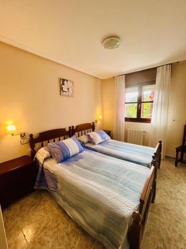 a bedroom with two beds and a window at Hotel las Palmeras Suite in Celorio