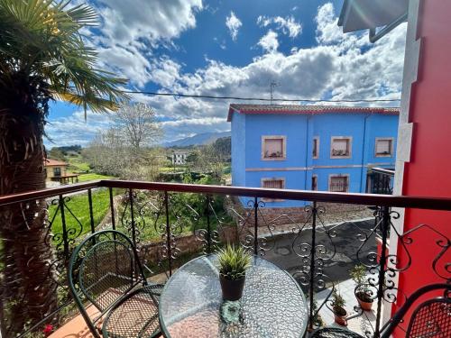 a balcony with a table and a blue building at Hotel las Palmeras Suite in Celorio