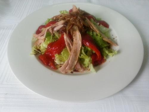 a white plate with a salad with meat and vegetables at Posada El Hoyal in Pesaguero-La Parte