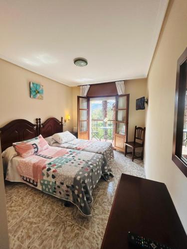 a bedroom with two beds and a window at Hotel las Palmeras Suite in Celorio