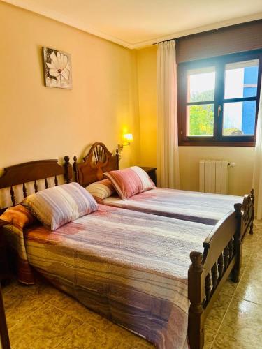 a large bed in a bedroom with a window at Hotel las Palmeras Suite in Celorio