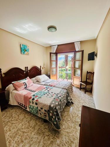 a bedroom with two beds and a window at Hotel las Palmeras Suite in Celorio