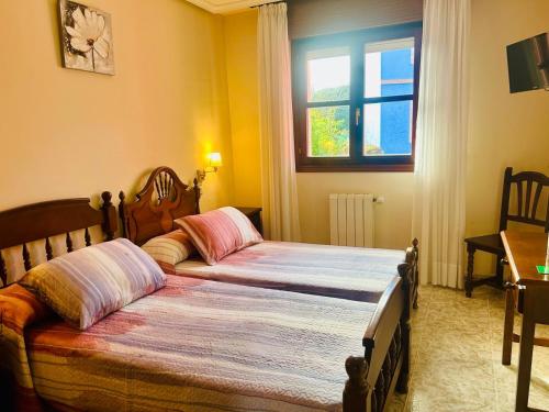 a bedroom with two beds and a window at Hotel las Palmeras Suite in Celorio