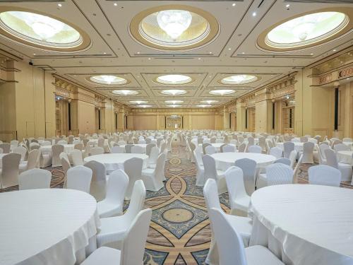 a room filled with white tables and white chairs at Sheraton Dammam Hotel & Convention Centre in Dammam