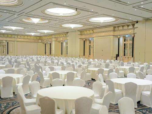 a large room with white tables and white chairs at Sheraton Dammam Hotel & Convention Centre in Dammam