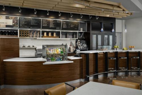 a bar in a restaurant with a counter and chairs at Courtyard by Marriott Salisbury in Salisbury